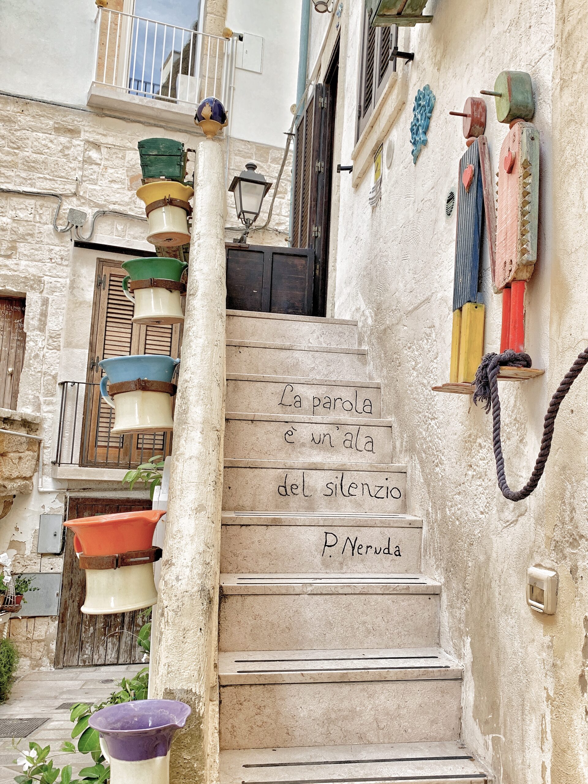 The streets, walls and doors of Polignano’s old town are decorated with poetry drawn by Guido Lupore, using the tag Guido il Flâneur. Photo the Puglia Guys for The Big Gay Podcast from Puglia
