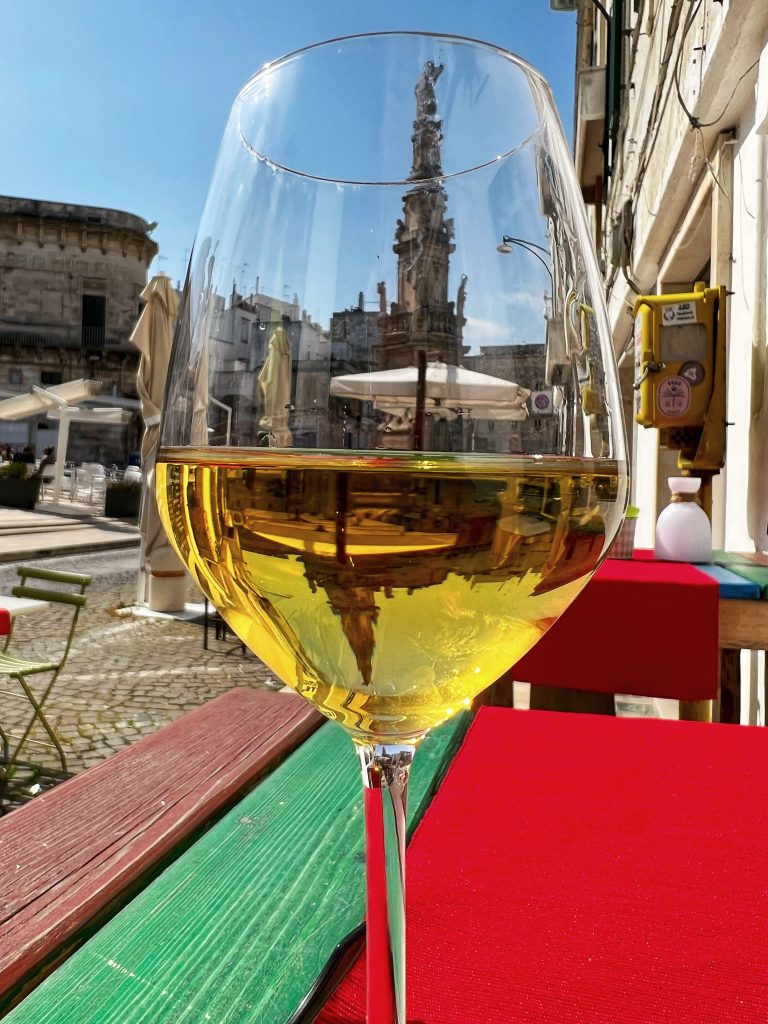A glass of fiano white wine from Puglia’s enjoyed outside Cicinedda Fruit Bistrot, Ostuni. Photo copyright the Puglia Guys for the Big Gay Puglia Guide.