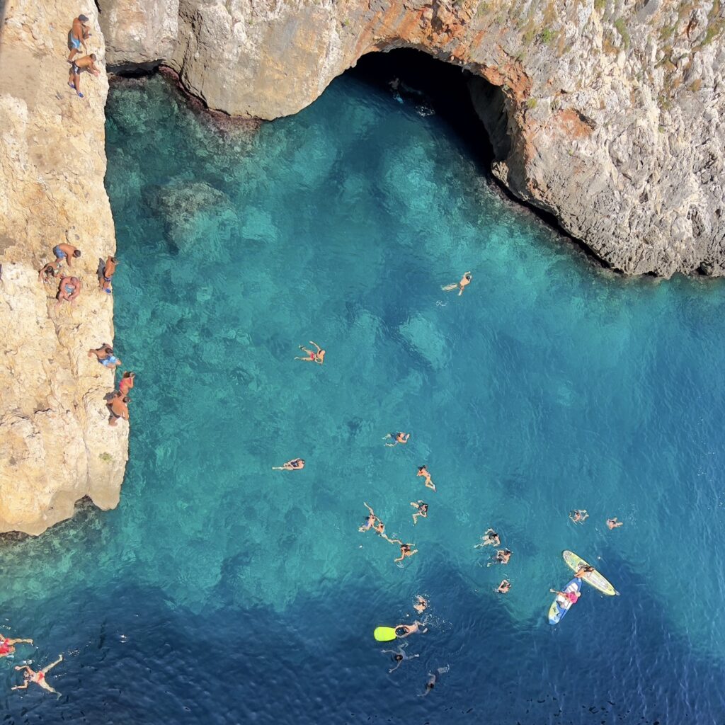 Il Ciolo, a secret beach and swimming spot where a small channel runs through a canyon under the bridge | Photo © the Puglia Guys for the Big Gay Podcast from Puglia guides to gay Puglia, Italy’s top gay summer destination | Puglia by beach guide to Puglia’s best beaches