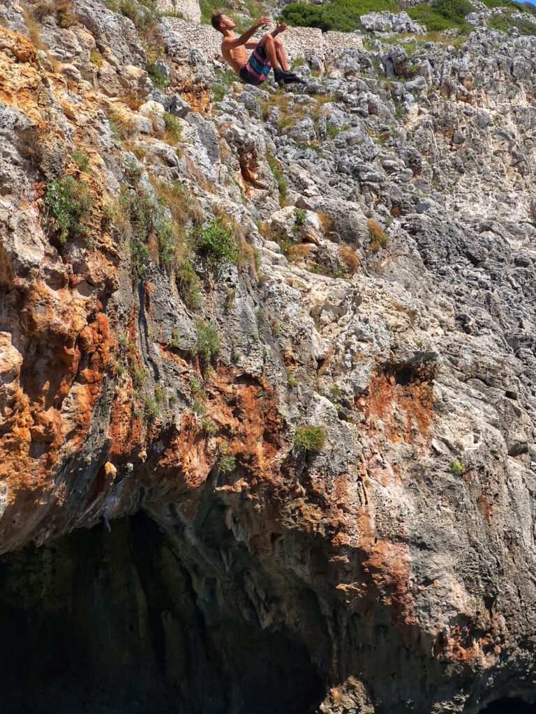 Jumping off the cliff at il Ciolo, Gagliano del Capo - one of Puglia’s most beautiful swimming spots, in a dramatic canyon underneath a bridge | Photo © the Puglia Guys for the Big Gay Podcast from Puglia guides to gay Puglia, Italy’s top gay summer destination