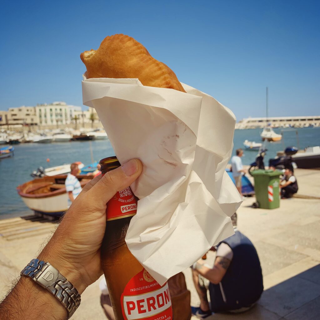 A panzerotto, epic street food from Bari, Puglia. Tiella is the local dialect for the terracotta dish it is baked in | the Puglia Guys guides to Puglia’s best food and restaurants Photo © the Puglia Guys for the Big Gay Podcast from Puglia guides to gay Puglia, Italy’s top gay summer and destination. One of Italy’s best foodie destinations.