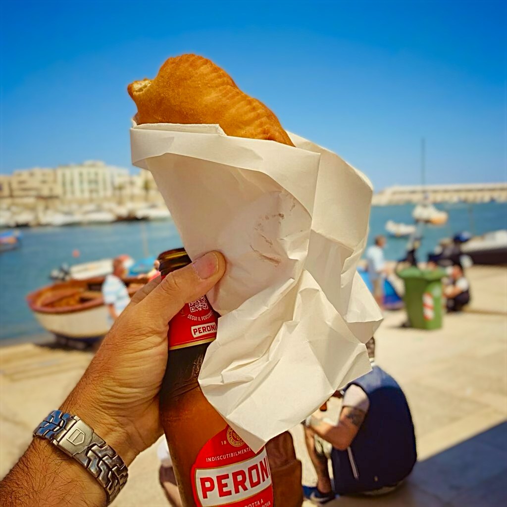 A panzerotto, epic street food from Bari, Puglia. Tiella is the local dialect for the terracotta dish it is baked in | the Puglia Guys guides to Puglia’s best food and restaurants Photo © the Puglia Guys for the Big Gay Podcast from Puglia guides to gay Puglia, Italy’s top gay summer and destination. One of Italy’s best foodie destinations.